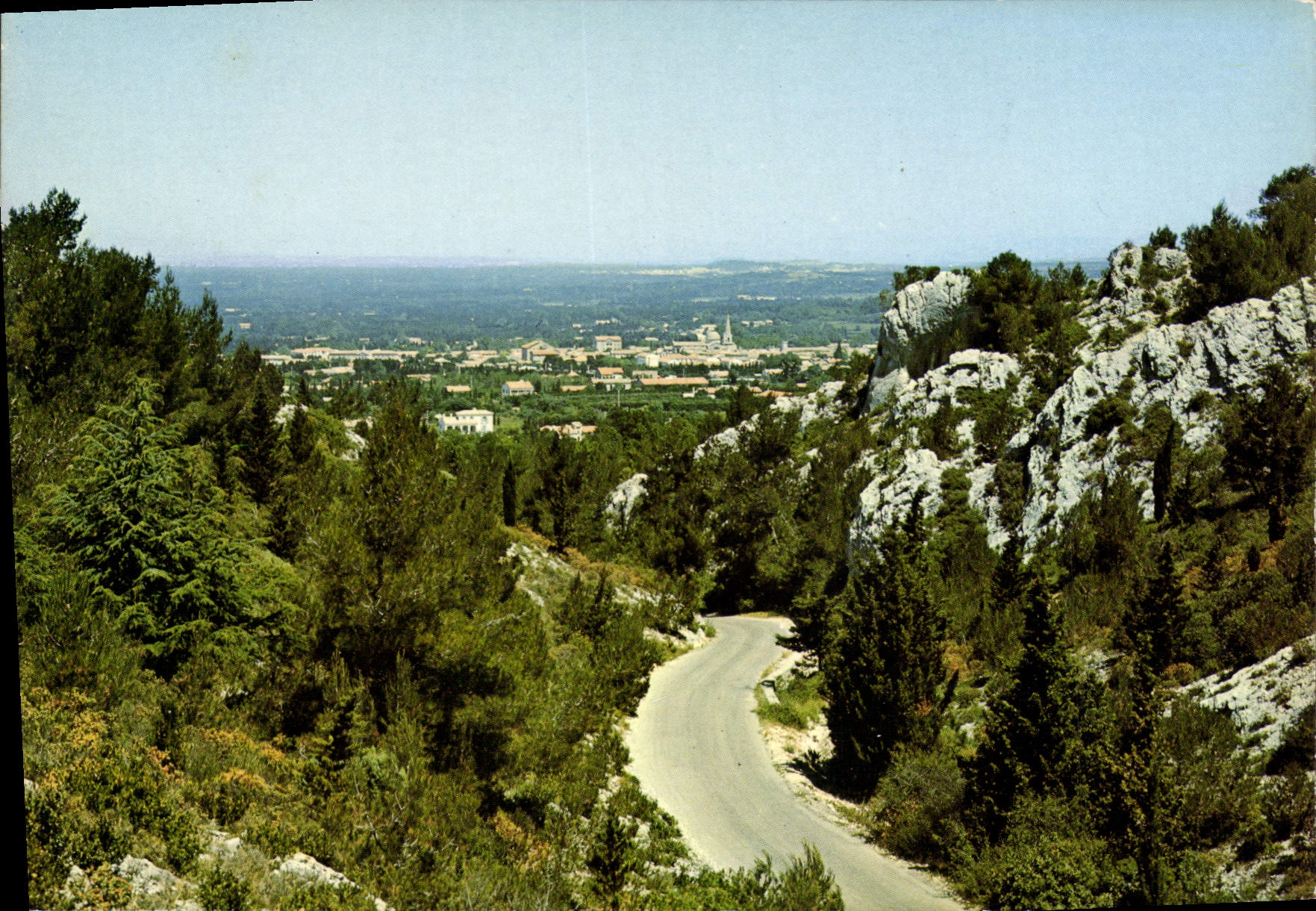 CPM Saint Remy de Provence la route venant du Lac au milieu des Alpilles au fond vue generale sur la