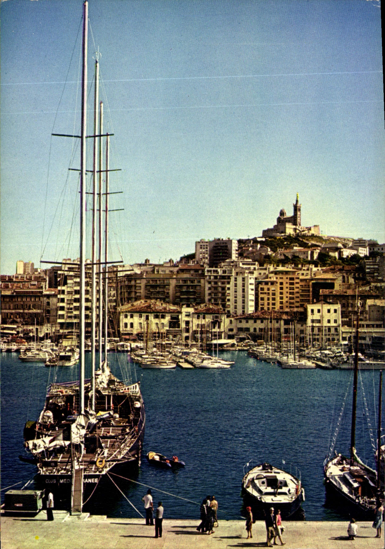 CPM Le Carrefour du Monde Marseille le Vieux Port dans le fond Basilique N D de la Garde Bateau