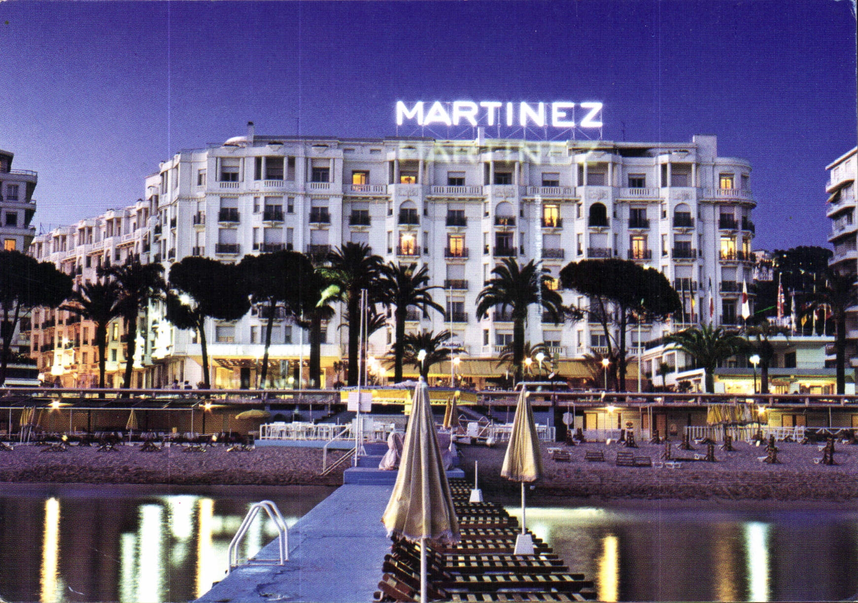 CPM Cannes Alpes Maritimes Sur la Croisette et en debut de soiree l'Hotel Martinez 