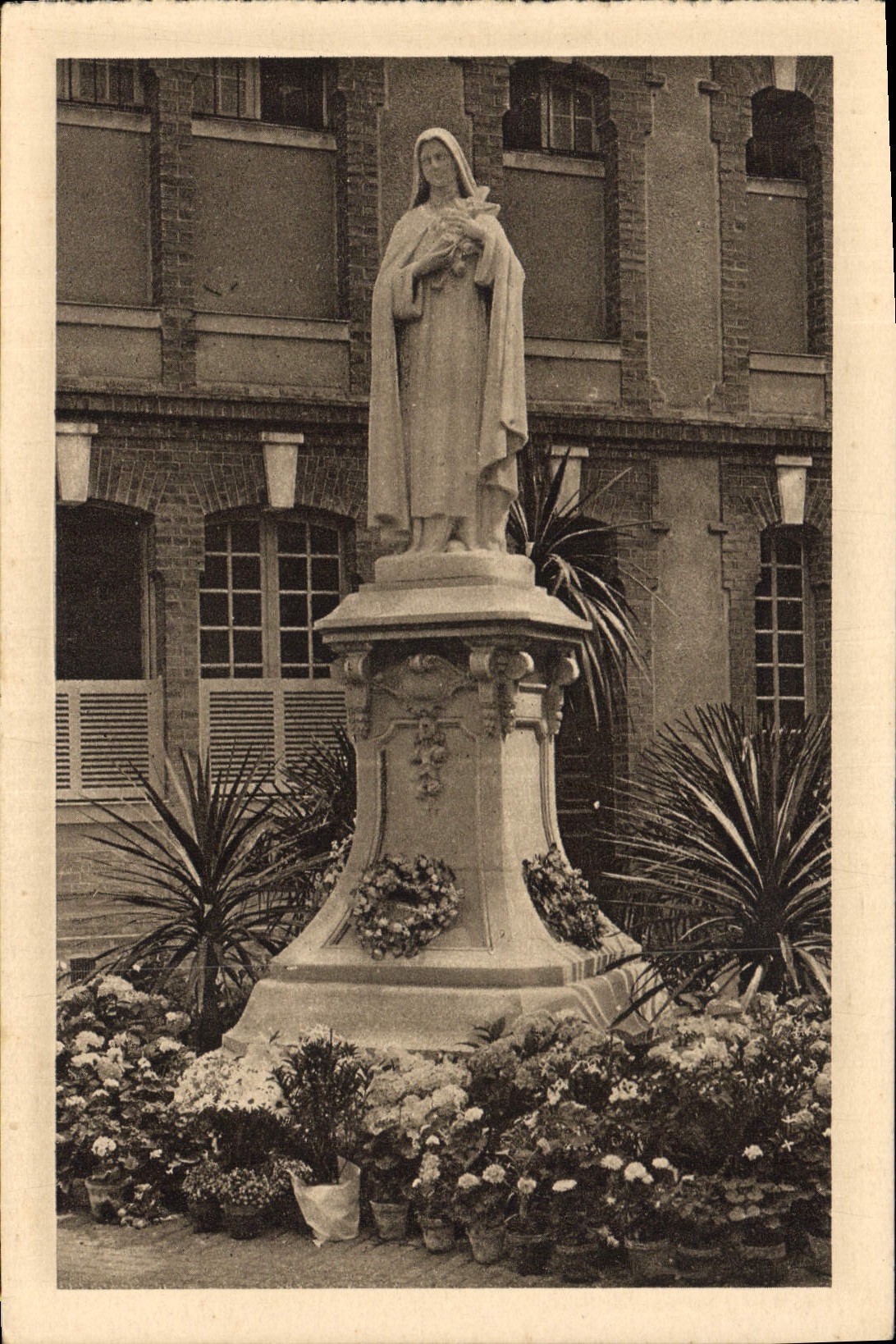 CPA La Statue de Sainte Therese de l'Enfant Jesus dans la cour d'entree 