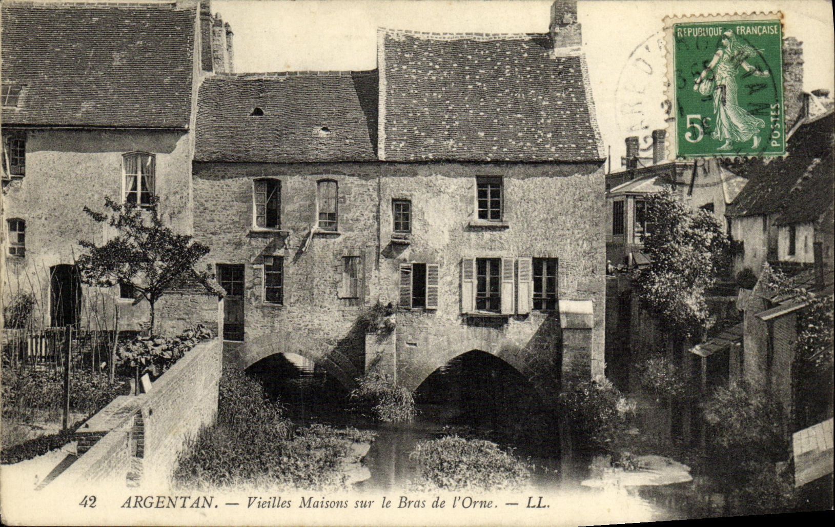 Las casas de las mujeres mayores de Argentan de la POSTAL de la VENDIMIA en el brazo de L adornan