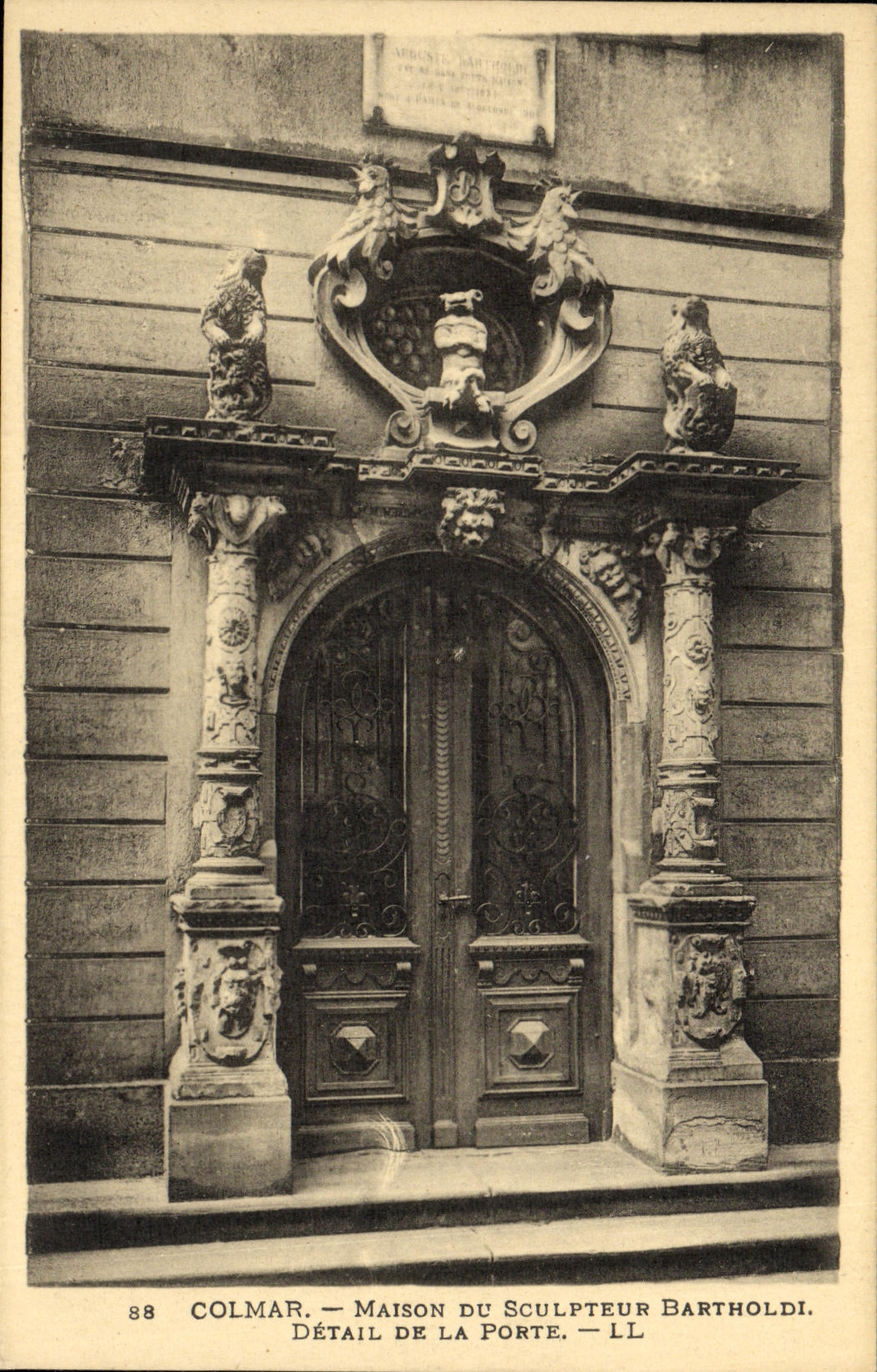 Casa de Colmar de la POSTAL de la VENDIMIA del detalle de Bartholdi del escultor de la puerta
