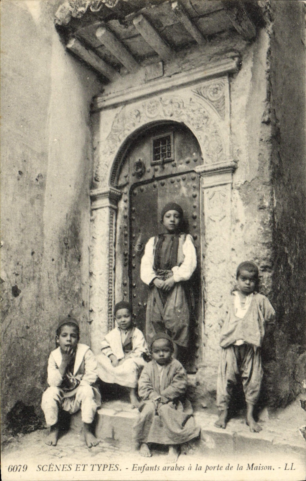 Escenas de la POSTAL de la VENDIMIA y niños árabes estándar en la puerta de la casa