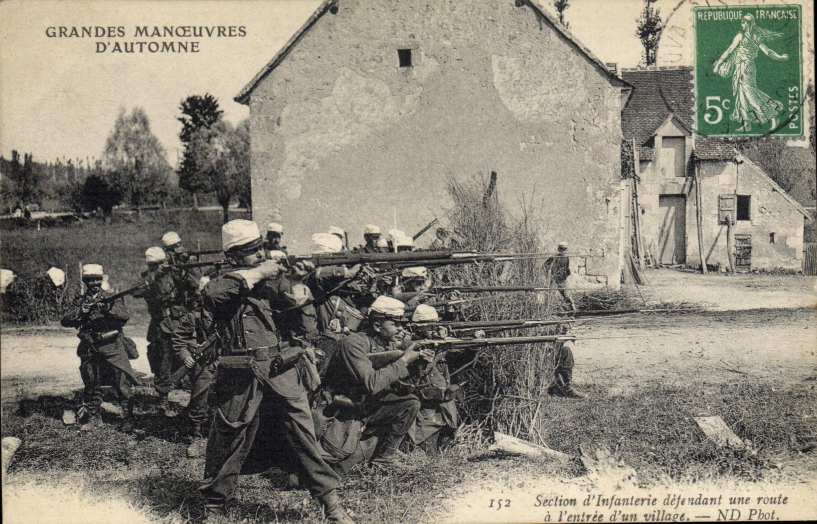 Maniobras del ejército de Militaria de la POSTAL de la VENDIMIA de la sección del otoño de la infantería que defiende un camino en la entrada de una aldea