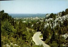 CPM Saint Remy de Provence la route venant du Lac au milieu des Alpilles au fond vue generale sur la