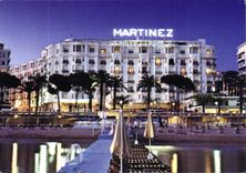 CPM Cannes Alpes Maritimes Sur la Croisette et en debut de soiree l'Hotel Martinez 