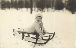 Real photo Child and toboggan (winter sports)