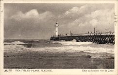 La playa de Deauville de la POSTAL de la VENDIMIA floreció efecto luminoso hacia el faro del embarcadero